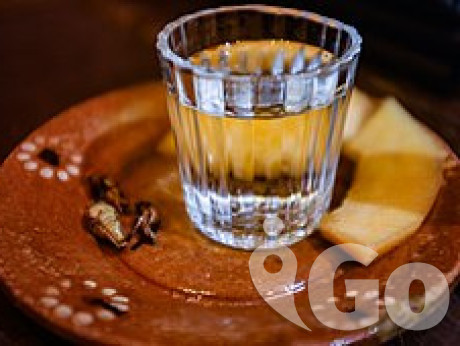 Mezcal de la Sierra Norte de Puebla servido con melón y chapulines